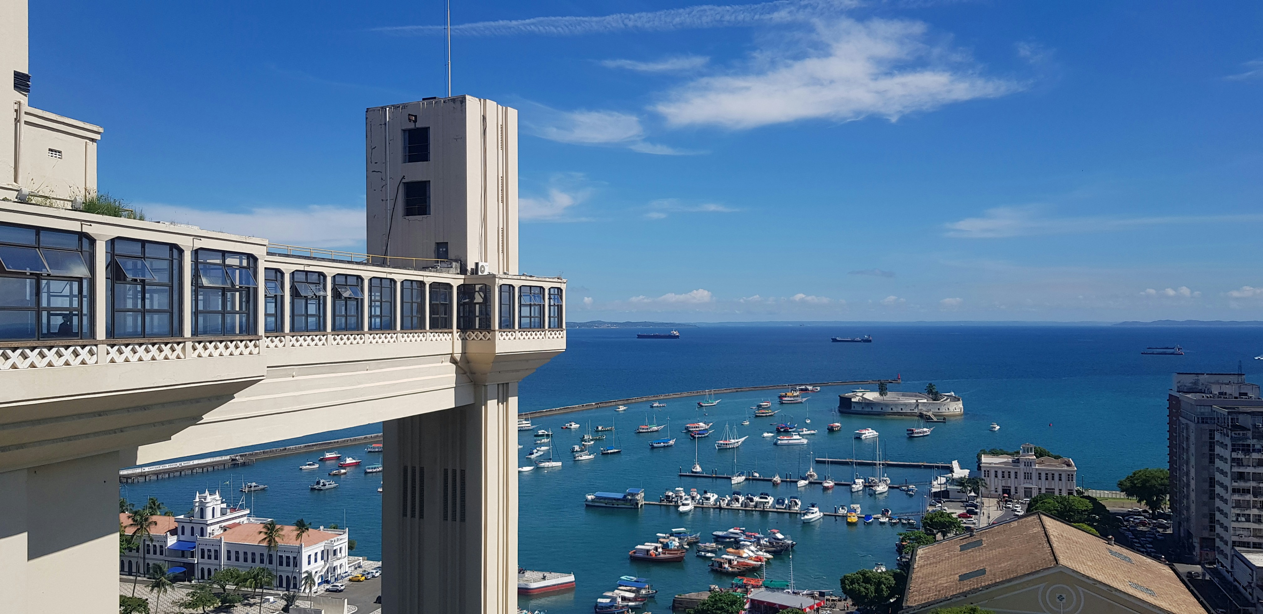 Barcos brancos ancorados no mar durante o dia em frente ao Elevador Lacerda em Salvador (BA)